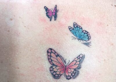 Tattoo fine line con farfalle colorate realizzato da Giorgia Arzenton