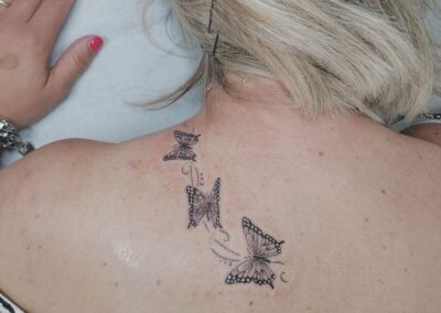Tattoo fine line con farfalle sulla schiena realizzato da Giorgia Arzenton