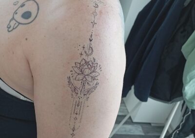 Tattoo fine line simbolico con fiore di loto sul braccio realizzato da Giorgia Arzenton