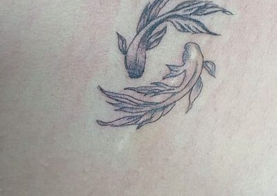 Tattoo fine line con due pesci koi minimal realizzato da Giorgia Arzenton