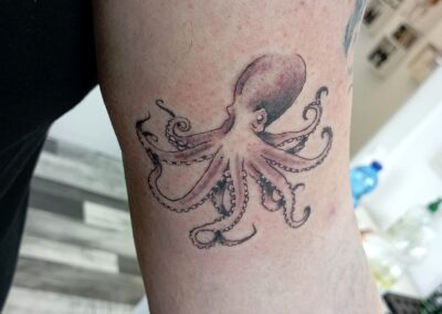 Tatuaggio fine line con polpo in stile black and grey realizzato ad Aurea Studio